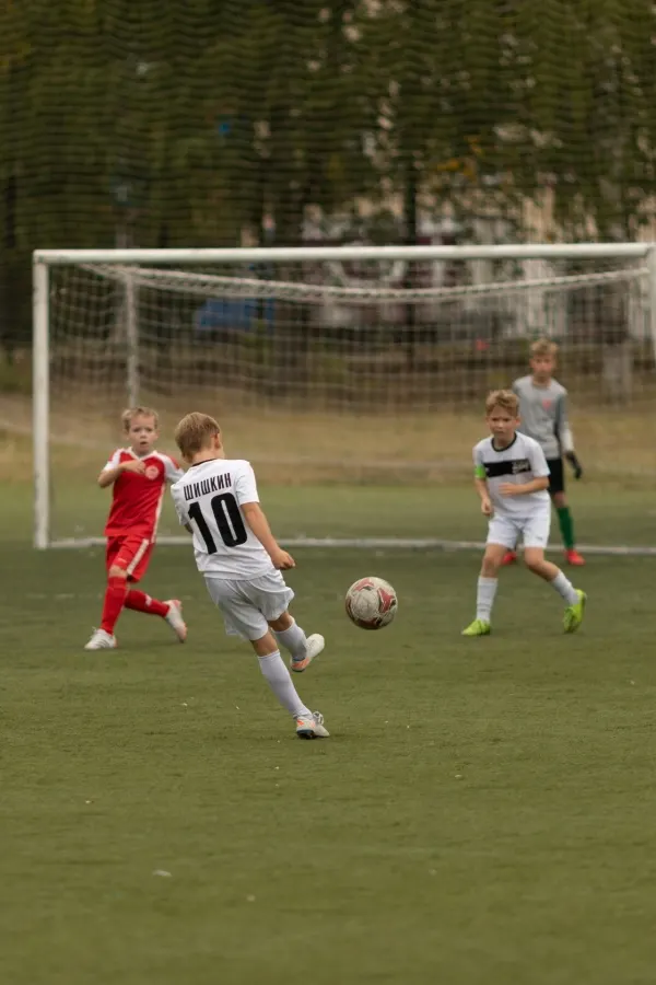 Youth soccer match — number 10 striking the ball toward the goal